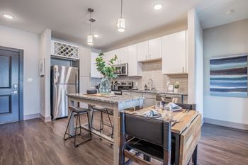 A modern kitchen with a wooden island and bar stools.